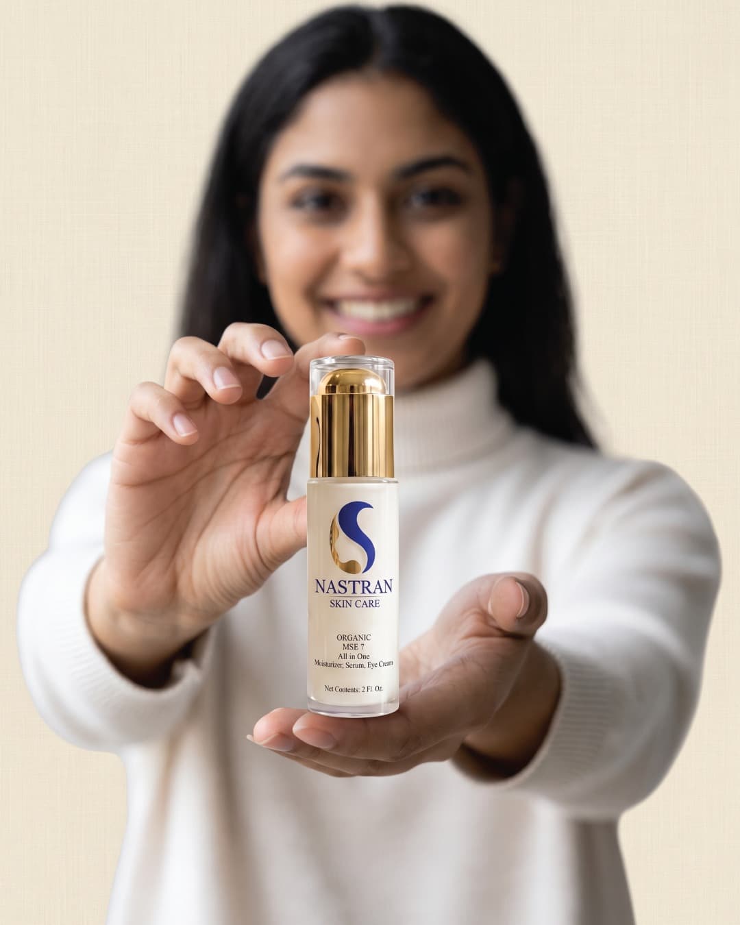 A woman in a white sweater holding the Organic MSE 7 bottle out toward the camera